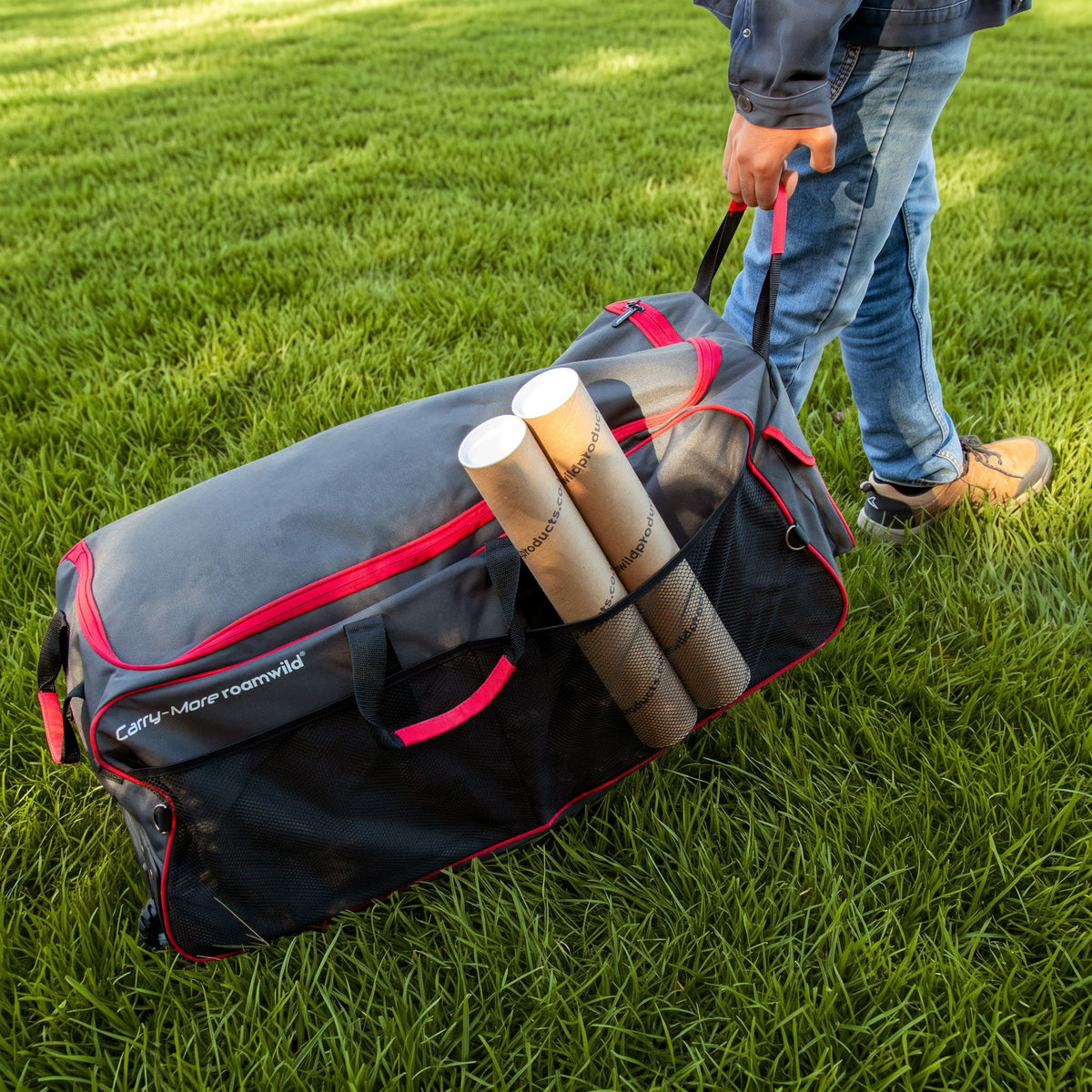 Carry-More pulled across a lawn by its handle, with tubes in the side mesh pocket